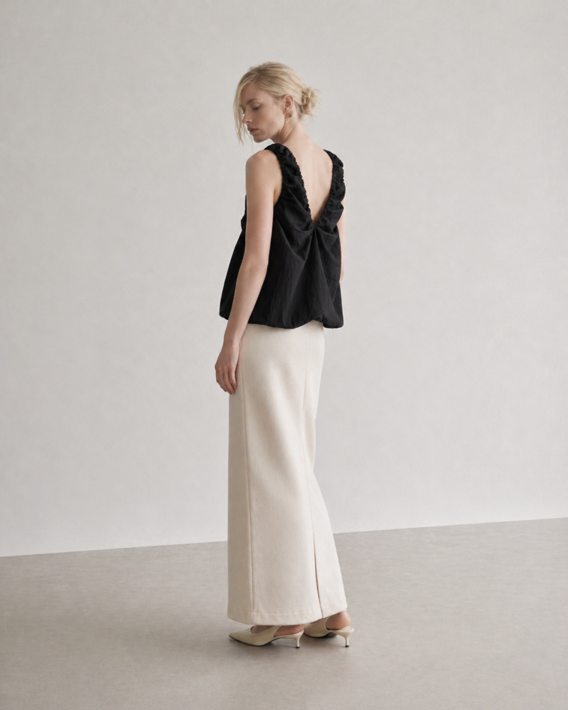 Woman wearing a black top and white pants 